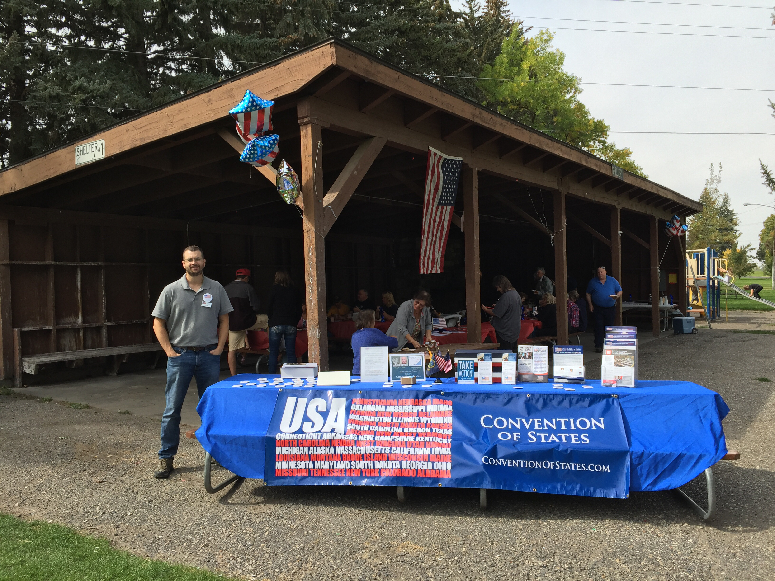 Idaho Falls area picnic with SIA Brian Gross standing beside the display table